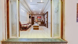 A reception area with a reception desk, seating area, and a decorative wall.