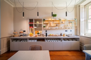 Una cocina moderna con estantes empotrados, una mesa de comedor e iluminación colgante.