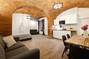 A compact living space with a kitchen, a dining area, and a bedroom. - GuestHost - Porta Ovile Glam Home (Siena)