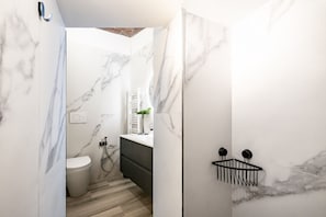 A modern bathroom with marble walls, a toilet, a sink, and a shower. - Elegant, fully renovated studio apartment sleeping up to 5 people, located in a period building just steps from Porta Ovile, one of the main entrances to the medieval heart of Siena. The area is well-served by all kinds of shops, and Piazza del Campo is  (Siena)