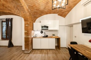 A compact kitchen with white cabinets, a wooden countertop, and a brick ceiling. - Elegant, fully renovated studio apartment sleeping up to 5 people, located in a period building just steps from Porta Ovile, one of the main entrances to the medieval heart of Siena. The area is well-served by all kinds of shops, and Piazza del Campo is  (Siena)