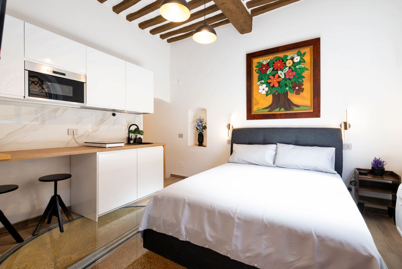 Un dormitorio con cama, escritorio y silla.