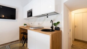 A modern kitchen with a built-in oven, a black sink, and a marble backsplash. - Charming studio apartment for two, renovated and located in a period building near Porta Ovile, one of the most convenient access points to the medieval heart of Siena. Its strategic location allows you to reach Piazza del Campo in about a 10-minute walk (Siena)