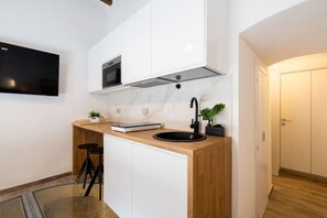 A modern kitchen with a built-in oven, a black sink, and a marble backsplash. - Charming studio apartment for two, renovated and located in a period building near Porta Ovile, one of the most convenient access points to the medieval heart of Siena. Its strategic location allows you to reach Piazza del Campo in about a 10-minute walk (Siena)