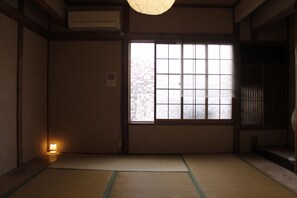 Ein traditioneller japanischer Raum mit Tatami-Boden, einer Schiebetür und einem Fenster mit Sandstrahlglas.
