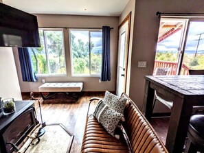 A cozy room with a sofa, a bench, a table, and a TV. - 11 Luminous Lodge in Santa Ysabel, CA (Santa Ysabel)