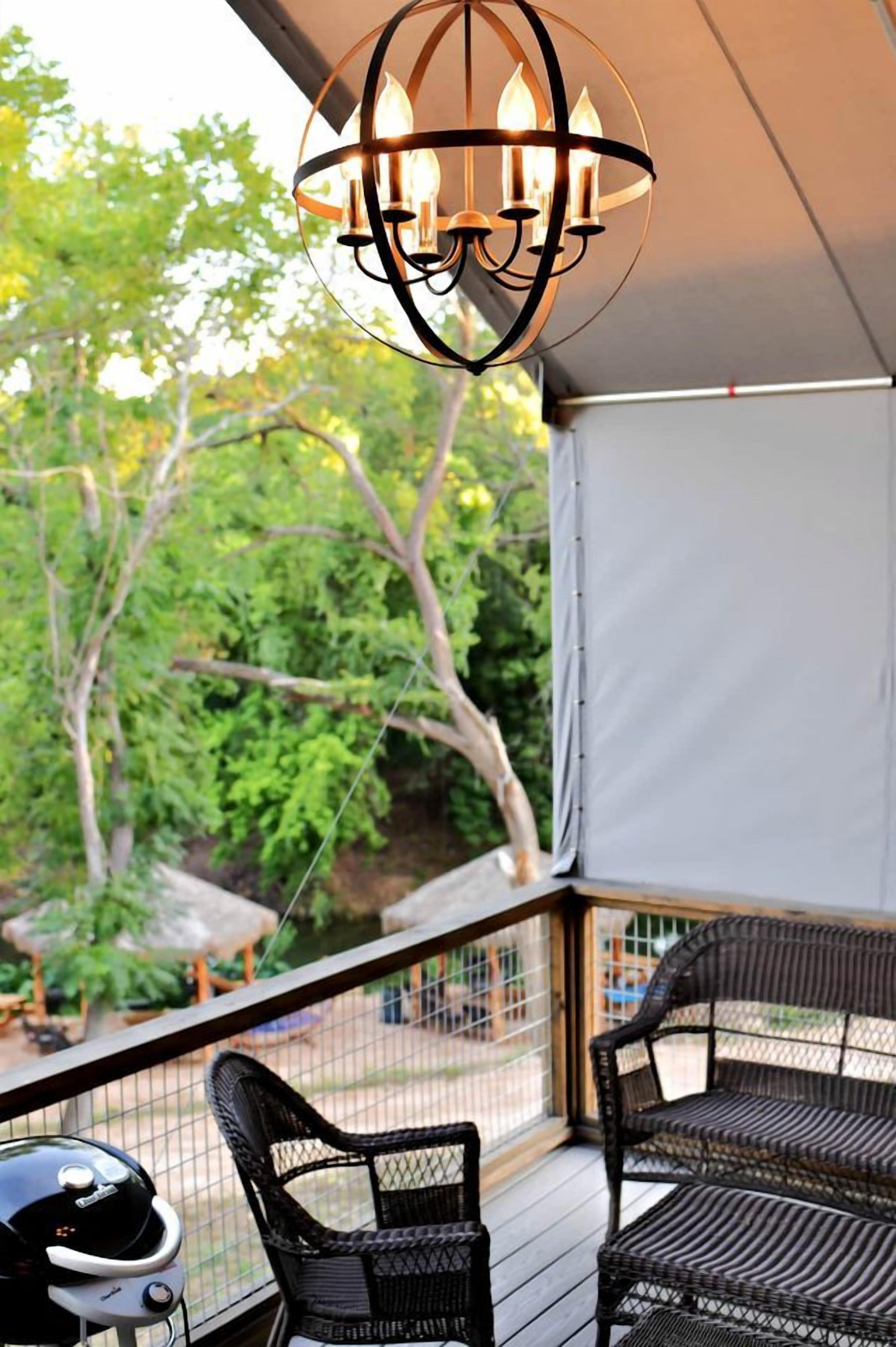 A covered outdoor area with wicker furniture and a grill.