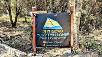 Señal de San Diego Mountain Lodge con cabañas y emplazamientos para vehículos recreativos, que incluye un número de contacto y sitio web.