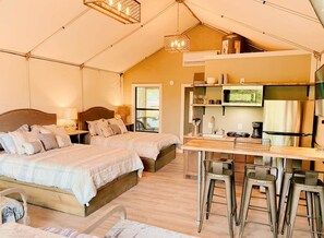Eine Zeltoase mit zwei Betten, einer Küchenzeile und einer Bar.