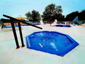Ein Schwimmbecken mit Liegestühlen und Sonnenschirmen.