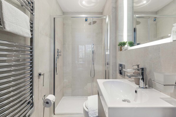 Un baño moderno con ducha, inodoro y lavamanos.