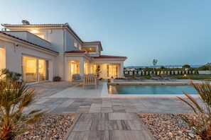 A modern house with a swimming pool, outdoor seating, and a view of the landscape. - Villa Emocija Zadarvilas (Vrsi)