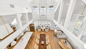 Un interior estilo loft, amplio y espacioso, con techo alto, ventanas grandes, zona de comedor y sala de estar.