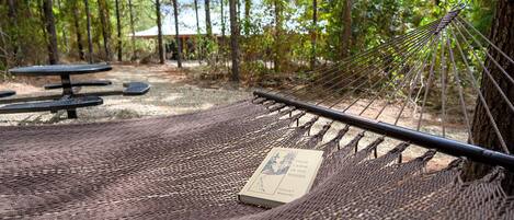 Una hamaca con un libro titulado 'Your Cabin in the Woods' de Conrad E. Melineck.