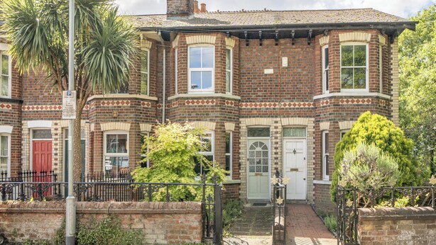 A Victorian-style brick house with a bay window, a red door, and a small garden with a palm tree. - Victorian Terrace Near Uni, Sleeps 6, Garden (Reading)