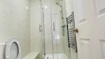 A bathroom with a toilet, a shower enclosure, and a bathtub.