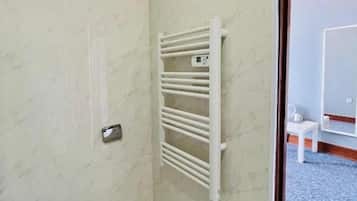 A bathroom with a white toilet, a towel rack, and a mirror.
