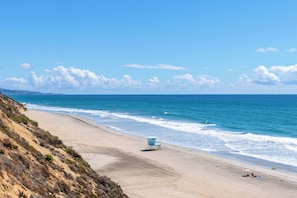 A beach with a lifeguard tower, sandy shore, and ocean waves. - Solana Luxe - New! Luxury Remodeled Oceanfront with AC (Solana Beach)