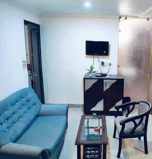 Quarto triplo conforto, vista para a cidade | Área de estar | Smart TV 32 polegadas com canais a cabo