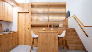 Une cuisine moderne avec des meubles en bois, une table à manger avec des chaises et un escalier avec une rampe en bois.