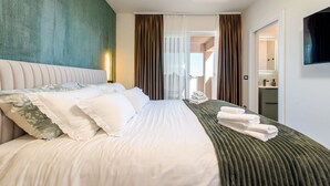 Una camera d'albergo con un letto, televisione, bagno e vista esterna.