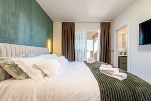 Een hotelkamer met een bed, een televisie, een badkamer en uitzicht.