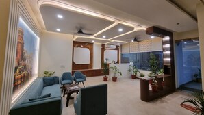 A modern reception area with a seating area, potted plants, and a large window. - Awesome 9-bedroom hotel with AC in vibrant Varanasi (Varanasi)