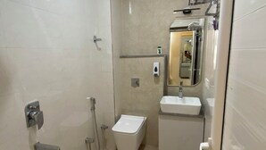 A bathroom with a shower, toilet, sink, and a mirror. - Awesome 9-bedroom hotel with AC in vibrant Varanasi (Varanasi)