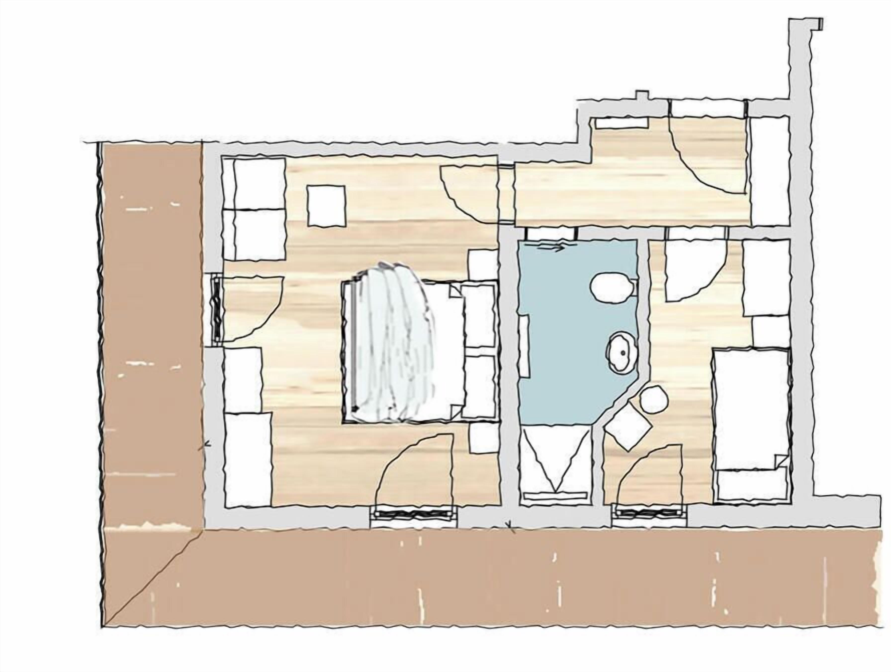 A floor plan of a hotel room with a bathroom, a kitchenette, and a small seating area.