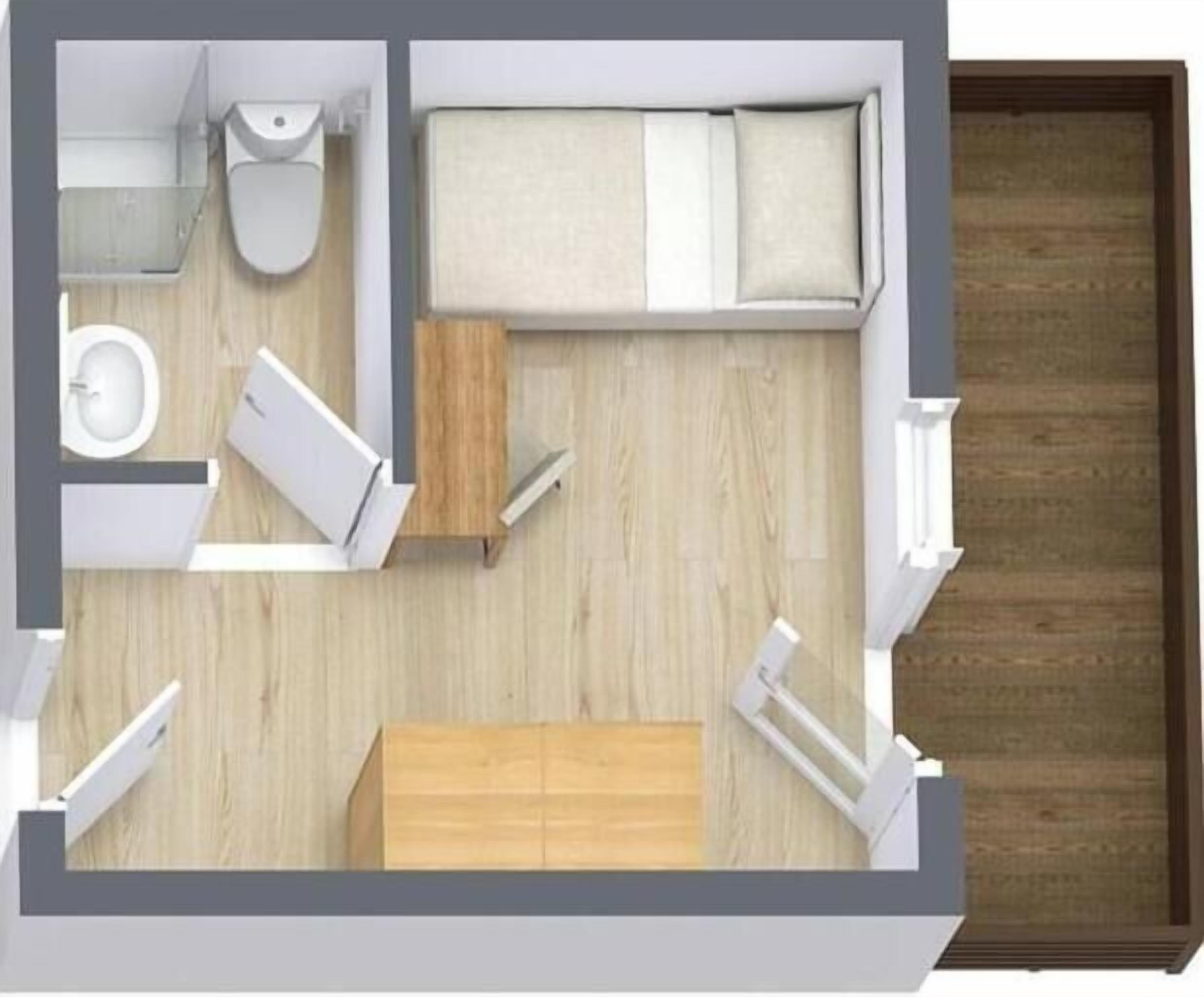 Una habitación con cama, mesita de noche, un pequeño armario de madera, inodoro y lavabo.