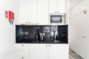 Eine moderne Küche mit Mikrowelle, Kaffeemaschine und Spüle.