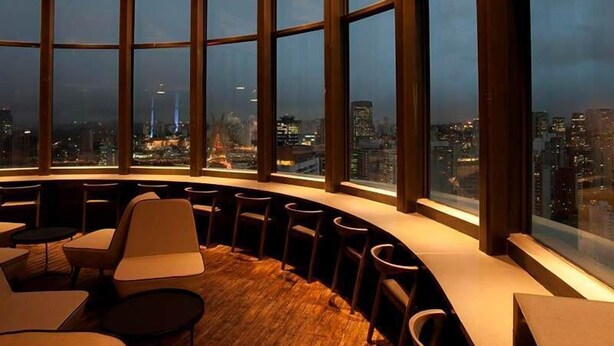 A high-rise interior with a curved seating area, large windows, and a cityscape view. - Berrini Mood Beautiful 1 BR in S o Paulo (São Paulo)