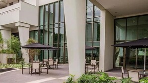 A modern building with large windows, outdoor seating, and a garden area. - Berrini Mood Beautiful 1 BR in S o Paulo (São Paulo)