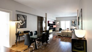 A modern living room with a dining area, a fireplace, and a large window. - El Jacaranda Large 3 BR With Balcony in Recoleta (Buenos Aires)