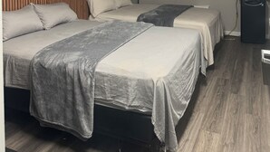 A hotel room with two beds, a microwave, a small refrigerator, and a ceiling light. - Richer Esso and Motel (Richer)
