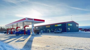 A gas station with ESSO branding, a SUBWAY, and a building with a red roof. - Richer Esso and Motel (Richer)