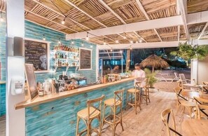 A bar area with a wooden ceiling, bar stools, and a chalkboard menu. - Playa Turquesa K403_200Mbps_Private Beach Access_Rooftop (Bavaro-Punta Cana)