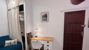 Quarto com cama, escrivaninha, cadeira, guarda-roupa e porta.