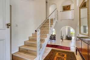 A staircase with wooden steps and white railings, leading to an upper floor.