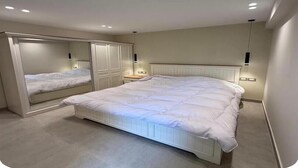 A bedroom with a large bed, a wardrobe, and a mirror. - Chic Stays - 3BR in Mountain View ICity October (Giza Governorate)