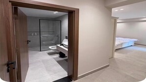 A modern bathroom with a glass shower enclosure, a toilet, and a sink. - Chic Stays - 3BR in Mountain View ICity October (Giza Governorate)
