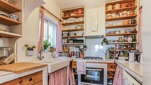 Eine Küche mit Holzböden, einem Gasherd und verschiedenen Küchenutensilien.