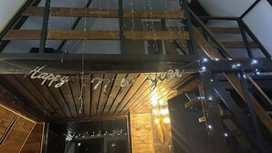 A wooden ceiling with exposed beams and string lights.