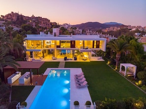 Ein modernes, zweistöckiges Haus mit Swimmingpool und Außenbereich.