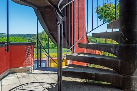 A staircase with metal railings leading to an outdoor area with a view of greenery.. Apartment 'Weingut Hirn &Hundertwasser-Artikel' with Mountain View, Shared Garden and Wi-Fi