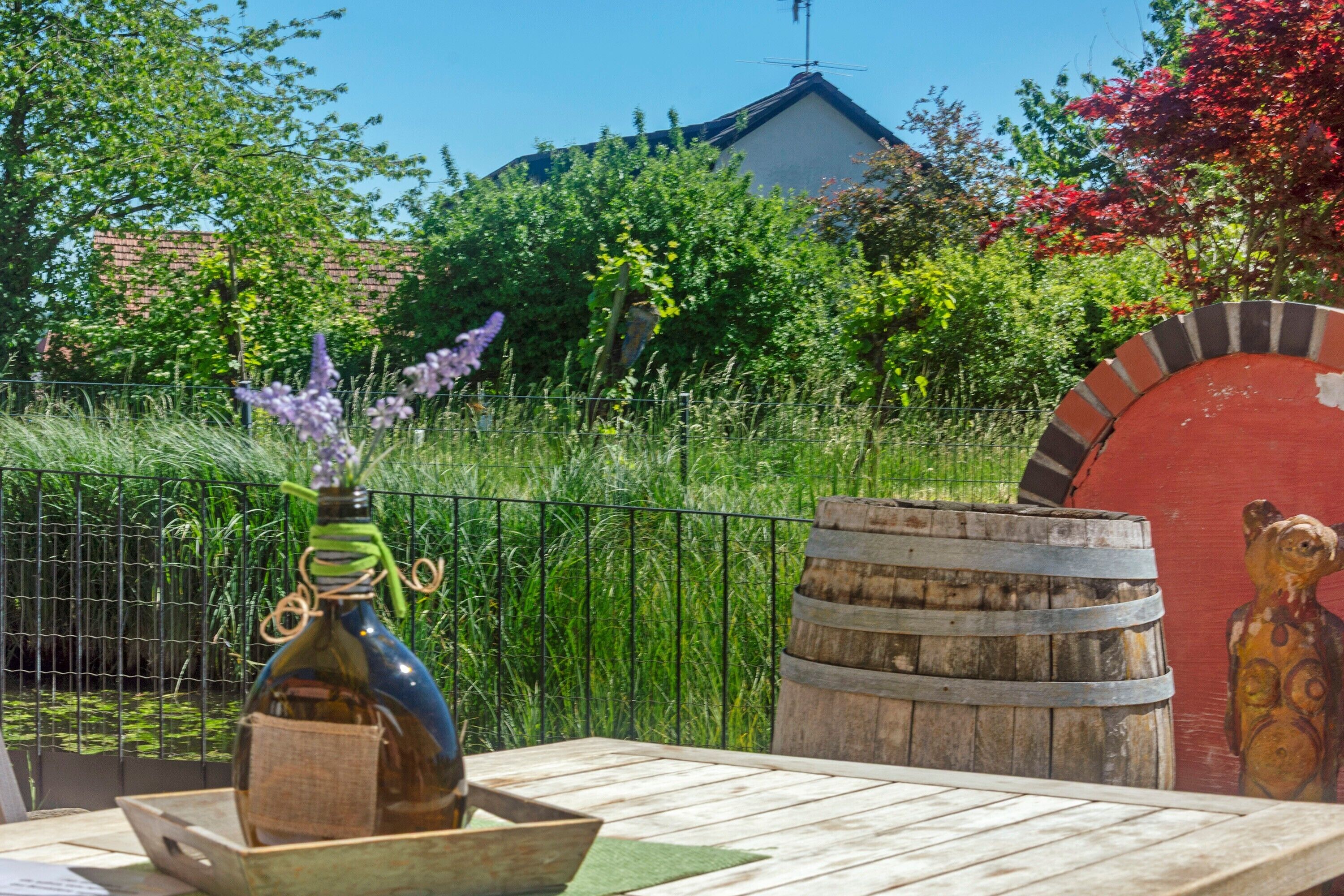 Une table en bois avec une bouteille et un bol, un tonneau et une fresque représentant un ours.