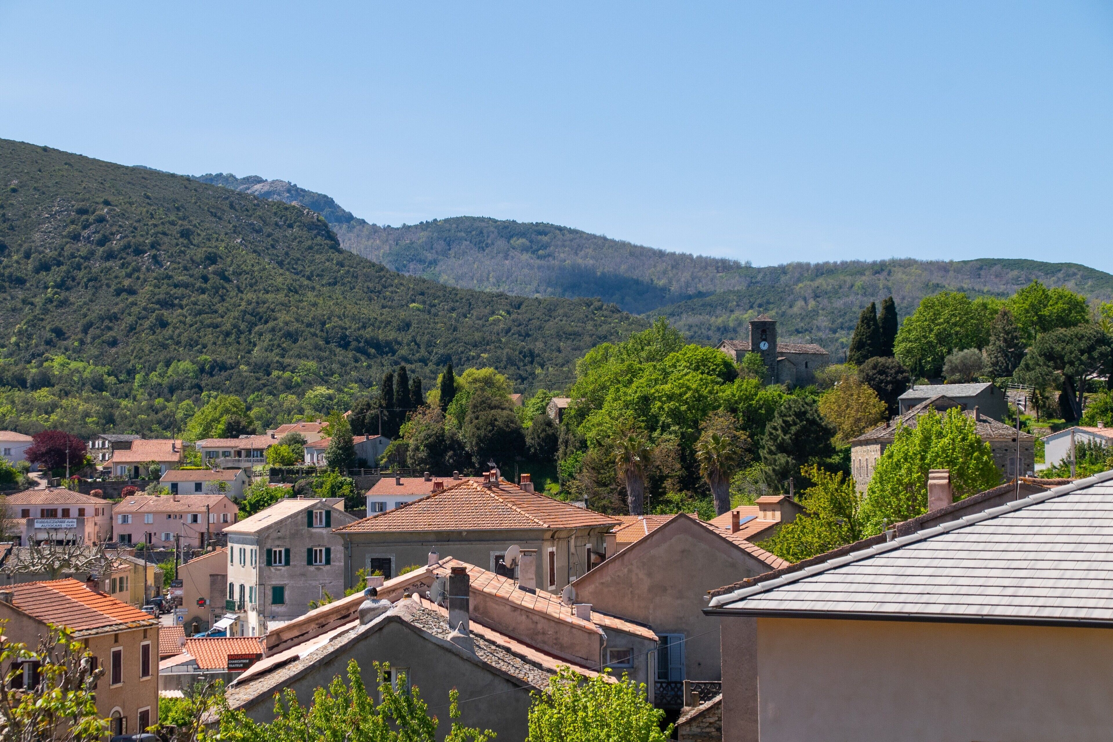 A town with buildings, a church, and a hill in the background.