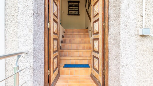A staircase leading to a room with a blue mat at the bottom.