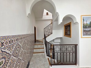 A staircase with ornate railings, a tiled wall, and a framed picture on the wall. - Riad Patio Des Amis Marrakech (Marrakech)