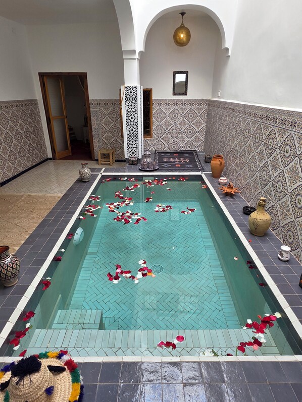 A swimming pool with decorative tiles and a hanging light fixture. - Riad Patio Des Amis Marrakech (Marrakech)